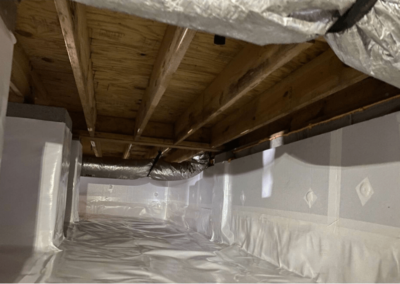 Sealed and encapsulated crawlspace with clean vapor barriers along the walls and floor, showing improved insulation and moisture control.