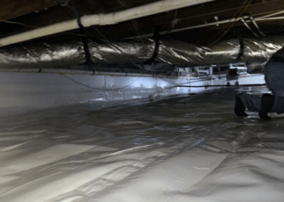 Completed crawl space encapsulation with a durable vapor barrier and sealed ducts for improved protection against moisture.