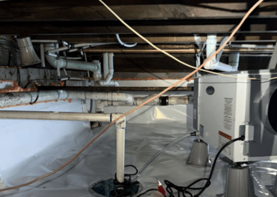 Crawl space with a sump pump system, dehumidifier, and insulated pipes for optimal water management and air quality.