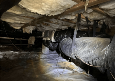 Crawl space showing deteriorated insulation and damaged ducts in need of repair and sealing.