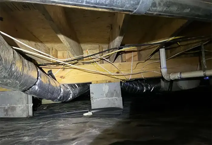 Before Unsealed crawl space with wires and block piers